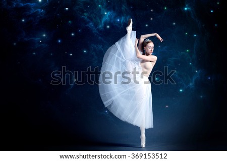 Young ballerina is dancing with the starry night sky in the background. Girl is wearing a beautiful dress that adds a romantic and wondering atmosphere to the photo.