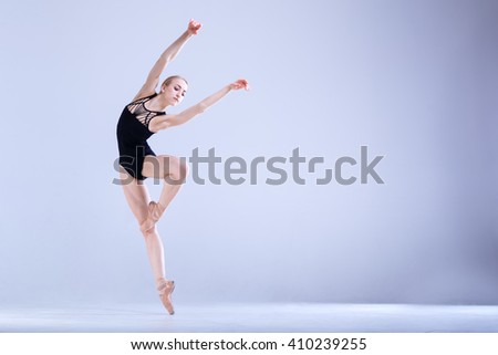 Young and incredibly beautiful ballerina is posing and dancing in a white studio full of light. The photo greatly reflects the incomparable beauty of a classical ballet art.