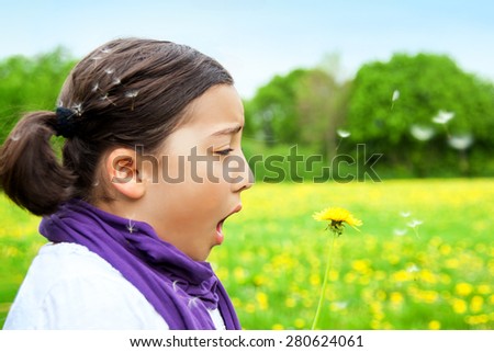 Allergy Hayfever Child. Pollen allergy, girl sneezing in a field of Dandelion flowers