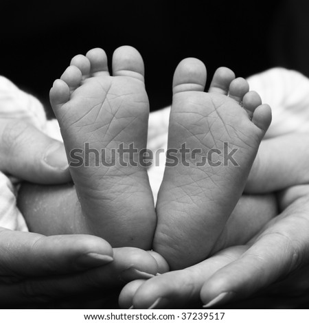 two little feet in the shape of heart in cuddling hands