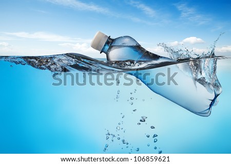 Swimming bottle of water in water on sky background