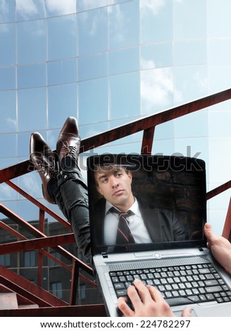 Mirrored portrait on screen of laptop of young businessman