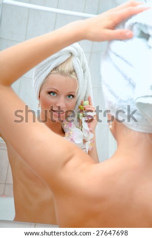 Portrait of the beautiful girl with a towel reflected in a mirror