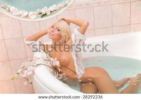 stock photo Beautiful naked blonde girl in white with a flowers