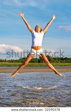 The young girl in a high jump from water