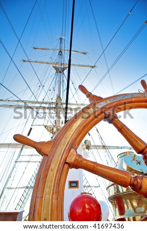 Close-up of a steering wheel against a mast of the sailing ship with focus on a wheel