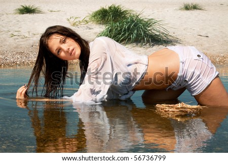 Picture of beautiful sexy bather  in wet white shirt on beach background