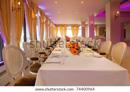 Festive decoration of table in pink lighting of restaurant.