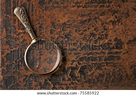 Magnifier on background cover of ancient book