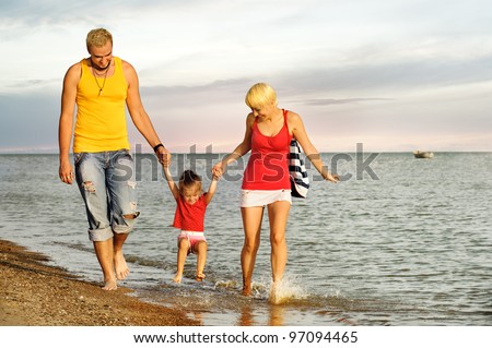 Picture of strolling young family on sea beach