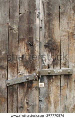 Old door with rusty padlock and rusty nails