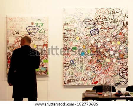 MILAN - MARCH 27: A man looks at paintings galleries during MiArt ArtNow, international exhibition of modern and contemporary art March 27, 2010 in Milan, Italy.