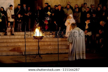 MANTOVA, ITALY - APRIL 03: Priest praying with the people after the lighting of the holy flame during Easter celebrations outside the cathedral of St. Andrew April 03, 2010 in Mantova, Italy.