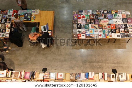 MILAN - APRIL 08: People look for books at library during MiArt, international exhibition of modern and contemporary art on April 08, 2011 in Milan, Italy