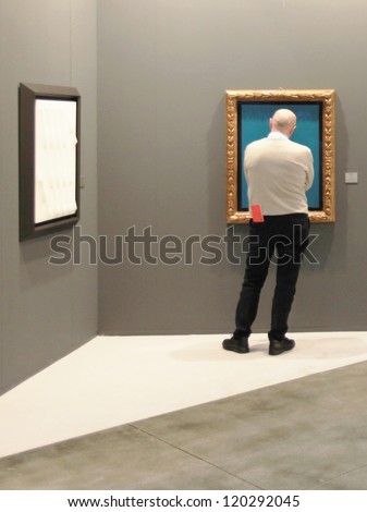 MILAN - APRIL 08: A man looking at paintings galleries during MiArt, international exhibition of modern and contemporary art on April 08, 2011 in Milan, Italy
