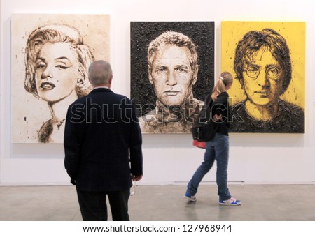 Milan - April 08: A Man And A Girl Look At Paintings Representing Marylin Monroe, Paul Newman And John Lennon At Miart, International Exhibition Of Modern Art On April 08, 2011 In Milan, Italy