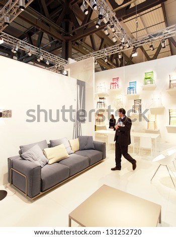MILAN - APRIL 17: A man looks at interior design solutions and accessories at Salone del Mobile, international furnishing and home accessories exhibition on April 17, 2012 in Milan, Italy.