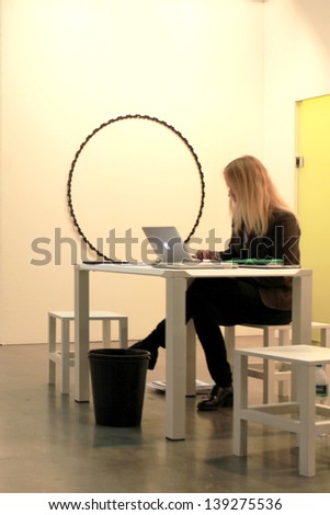 MILAN - APRIL 07: Woman at her desk during MiArt, international exhibition of modern and contemporary art April 07, 2013 in Milan, Italy.