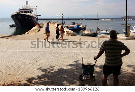 THASSOS, GREECE - JULY 9: People wait on the dock before boarding on the ship July 9, 2010 in Thassos, Greece.