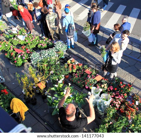 MILAN, ITALY - APRIL 14: People look for flowers during the annual Flowers Market in the fashion and culture Navigli area April 14, 2013 in Milan, Italy.