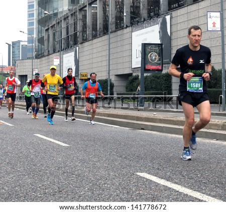MILAN - APRIL 07: A runner leading a group of athletes during the competition on the city streets at Milano City Marathon on April 07, 2013 in Milan, Italy.
