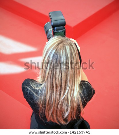 VENICE - SEPTEMBER 8: A photographer at work on the red carpet at 69th Venice Film Festival on September 8, 2012 in Venice, Italy.