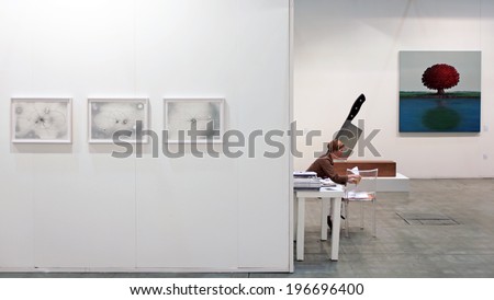 MILANO, ITALY - APRIL 08, 2011: A woman on a chair at paintings galleries during MiArt, international exhibition of modern and contemporary art in Milano, Italy