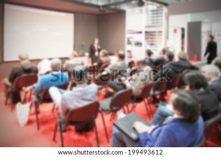 People in meeting. Intentionally blurred background.