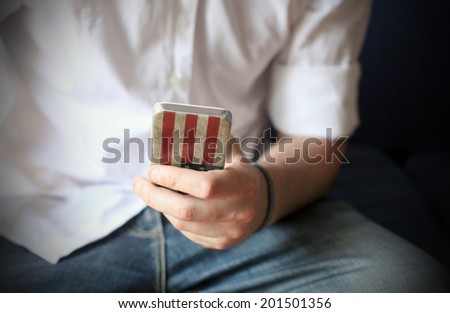 Man and his smart phone with US flag cover in his left hand