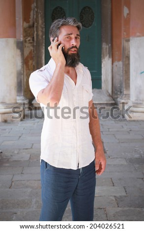 A man during a talk with his smart phone, old architecture background setting