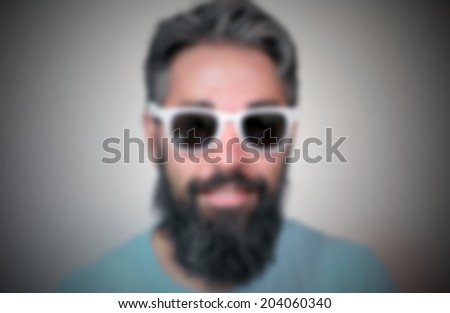 Hipster face, portrait of a man wearing white glasses, intentionally blurred background.