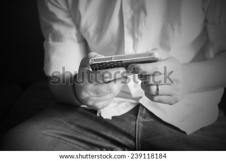 Man with his smart phone. Black and white background.