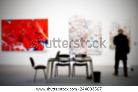Man in art gallery. Intentionally blurred background, people not recognizable.