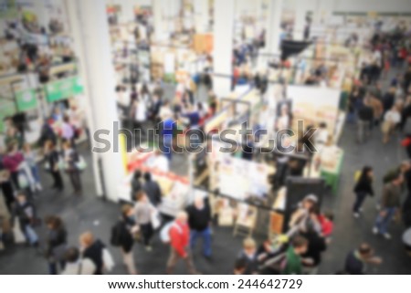 People crowd, panoramic view at trade show. Intentionally blurred post production.
