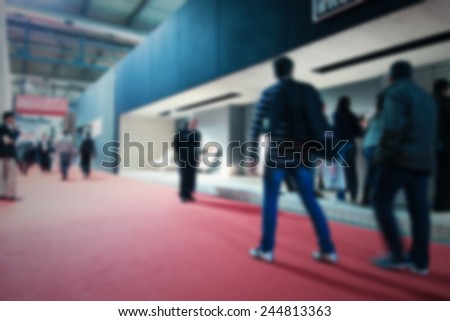 People visit a trade show, generic background. Intentionally blurred post production.