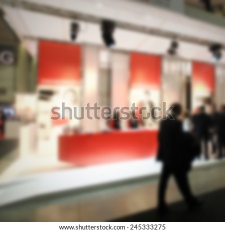 Man visits a trade show, humans not recognizable. Intentional blurred post production.