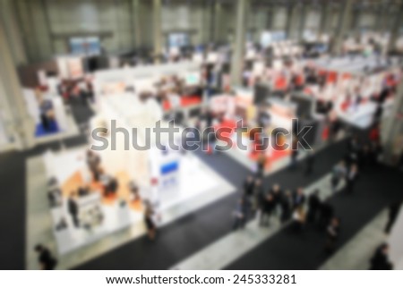 Trade show background, humans not recognizable. Intentional blurred post production.