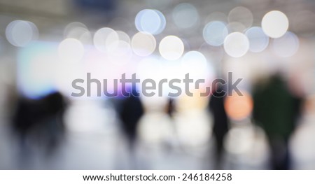 People visit a trade show, generic background, humans and location not recognizable. Intentionally blurred post production.