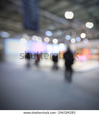 People visit a trade show, generic background, humans and location not recognizable. Intentionally blurred post production.