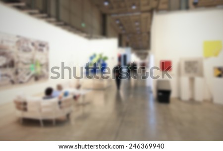 People visit art galleries, background with humans and location not recognizable. intentionally blurred post production.