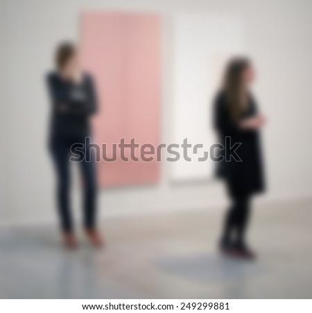 Women, art gallery generic background. Intentionally blurred post production, humans and location not recognizable.