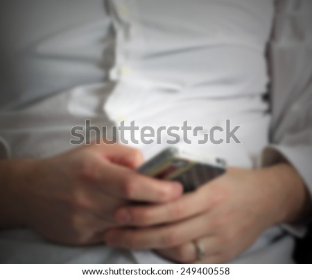 Man with his smart phone, us flag cover on the device. Intentionally blurred post production background.
