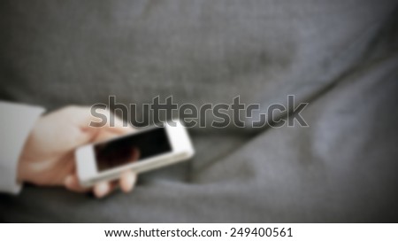Man's hand with his smart phone. Intentionally blurred post production background.