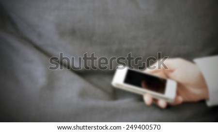 Man with his smart phone. Intentionally blurred post production background.