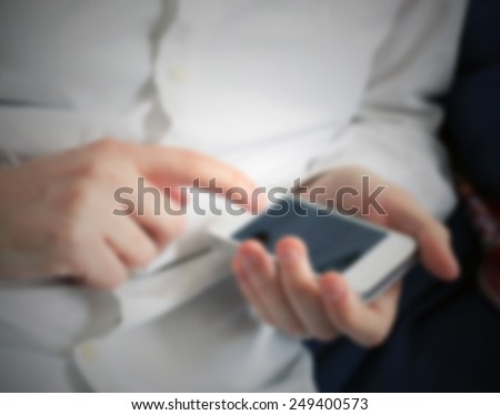 Man with his smart phone. Intentionally blurred post production background.