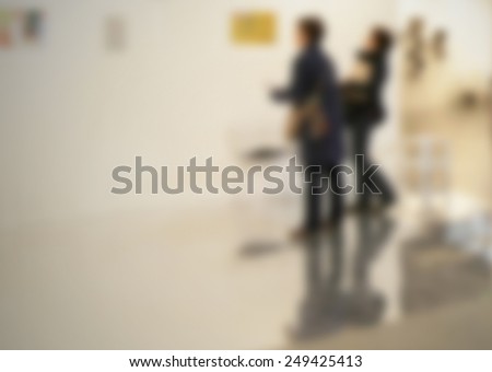 Women looking at works of art. Location, works and people not recognizable. Intentionally blurred post production background.