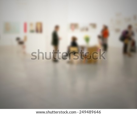 Panoramic view of people visiting an art gallery, generic background. Intentionally blurred post production background.