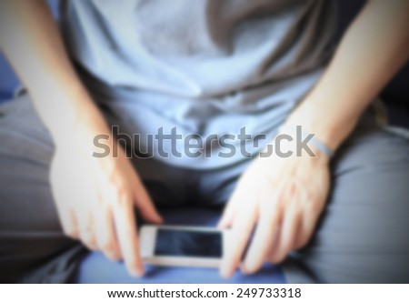 Man chatting with a smart phone. Intentionally blurred editing post production background.