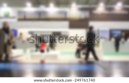 People walk at trade show exhibition. Intentionally blurred editing post production background.