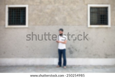 Man on the street with his smart phone. Intentionally blurred editing post production background.